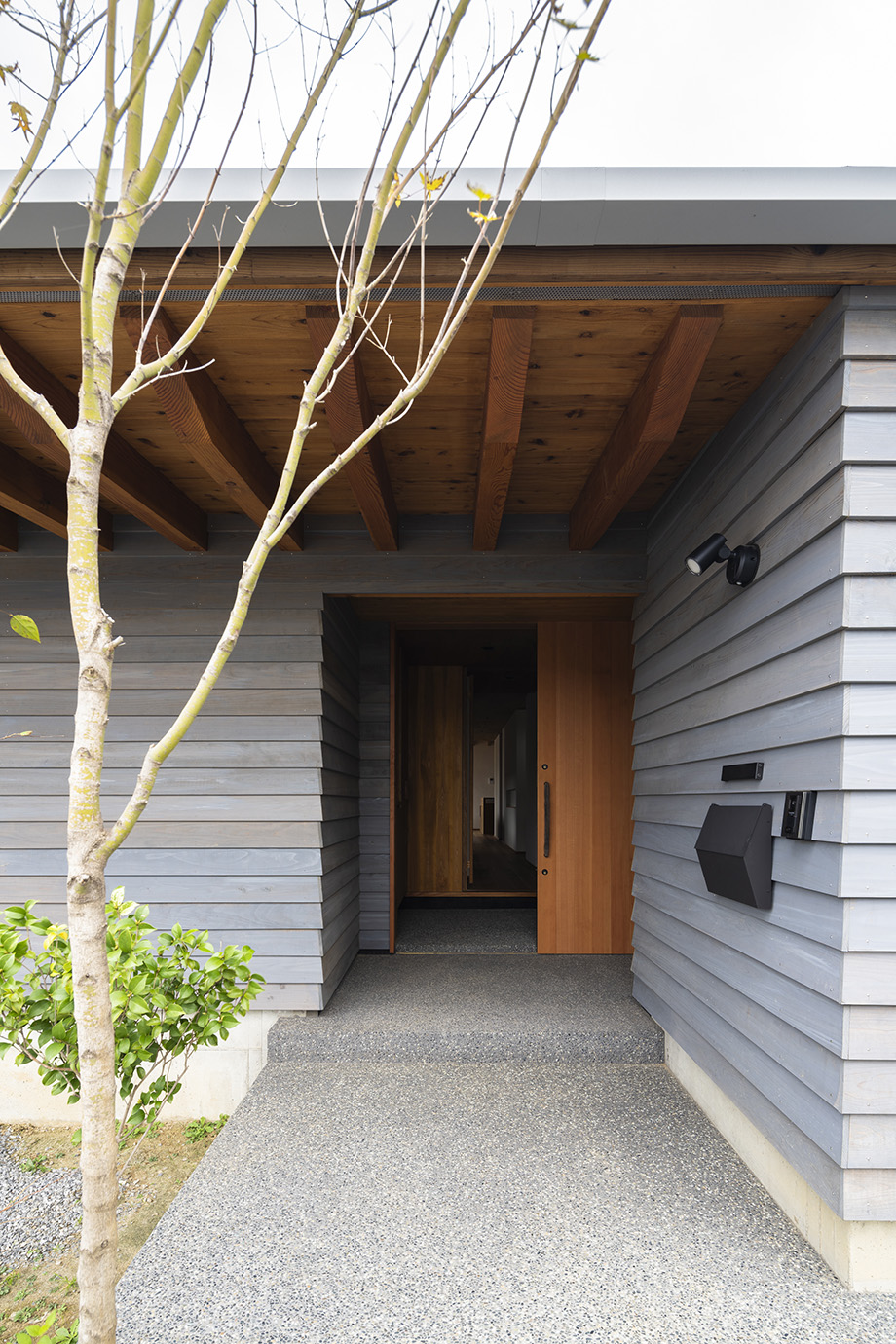 印旛郡の平屋「DL HOUSE」山武杉の下見板張りの外観 化粧登梁の軒下