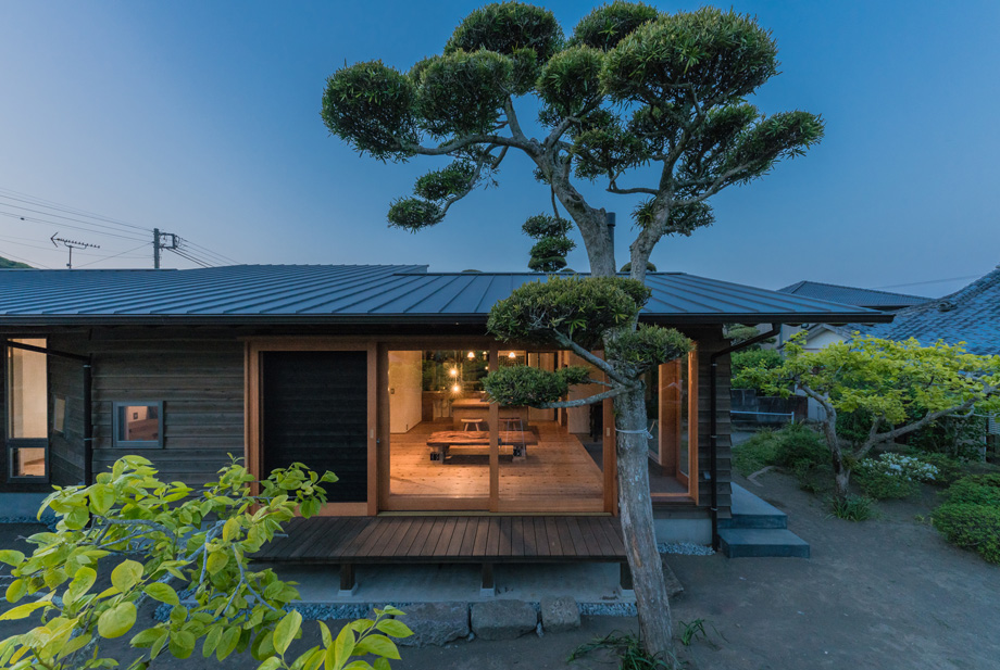 南房総市の平屋「白子の家」外観の夕景。木製サッシを全開した状態 低くて深い軒。