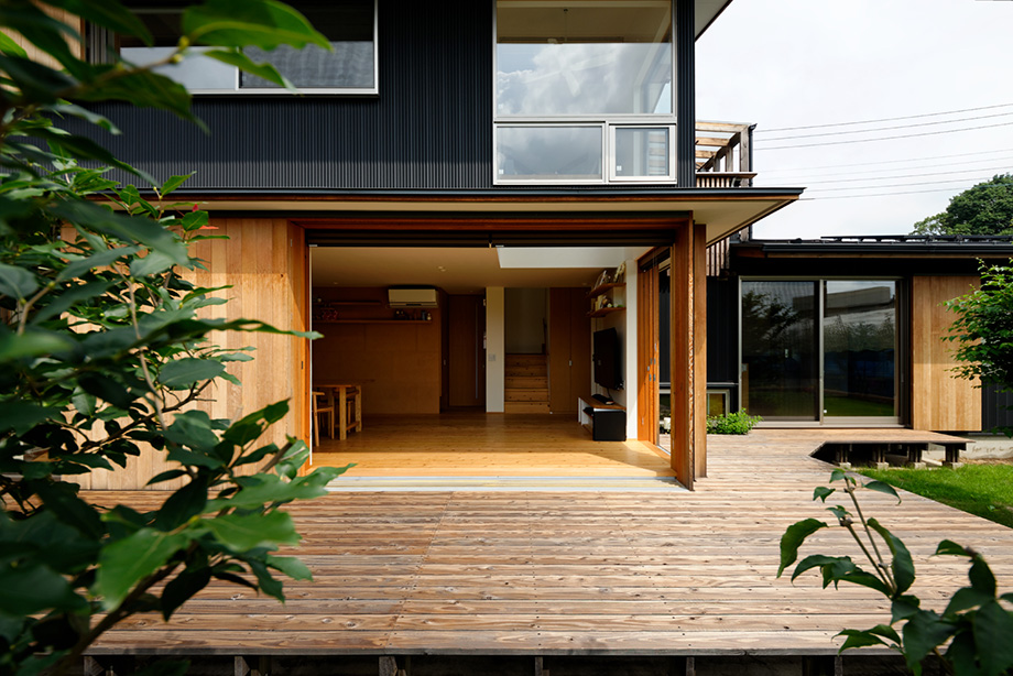 埼玉県「蓮田の家」木製全開サッシを全開した状態を南側のデッキから見ている。その奥にはリビングがあってデッキとリビングが一体化している