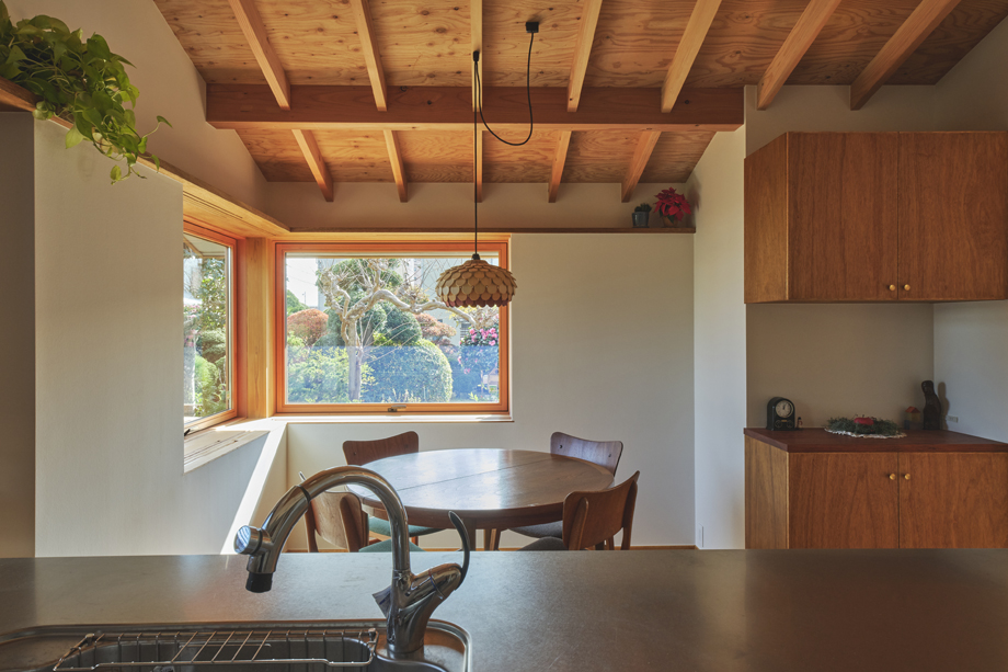 伊勢原市の平屋「私の巣」のダイニングの東南の角に設置した木製滑り出し窓　閉じた状態　化粧垂木のある空間