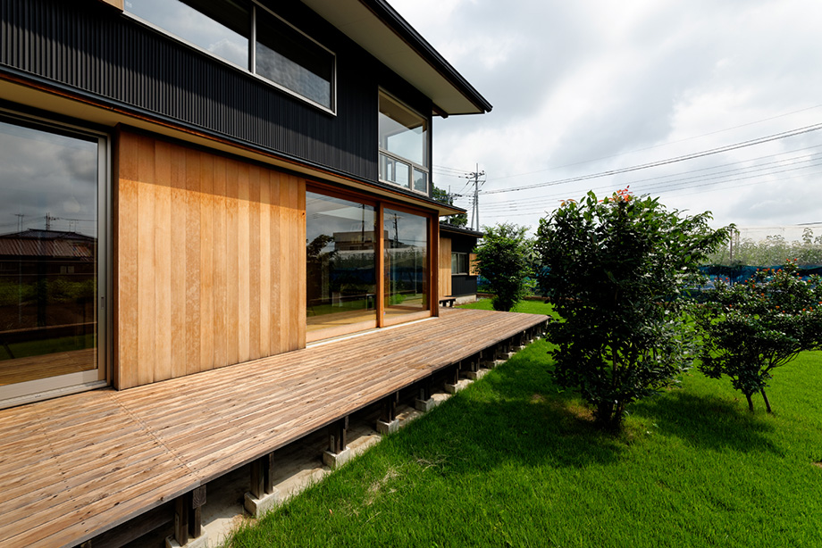 埼玉県「蓮田の家」木製全開サッシを全開した状態を南側のデッキから見ている。