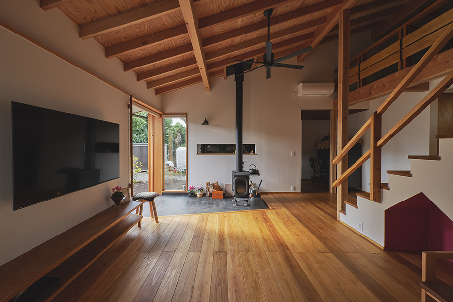 伊勢原市の平屋「私の巣」の薪ストーブのある山小屋のようなリビング。化粧垂木の勾配天井