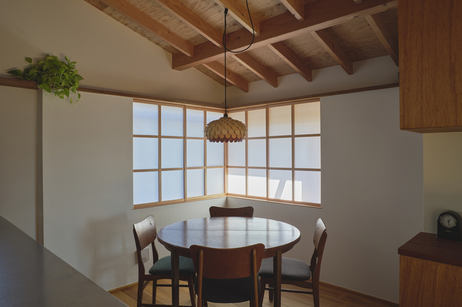 伊勢原市の平屋「私の巣」のダイニングの東南の角に設置した木製滑り出し窓　障子を閉じた状態　化粧垂木のある空間