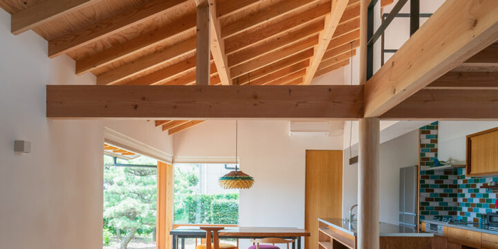 木製サッシで庭と繋がる開放的なダイニングと、落ち着きのあるリビング。大きな一つ屋根の下のワンルーム空間。