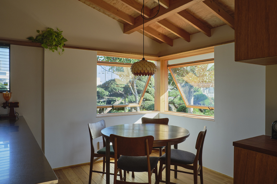 伊勢原市の平屋「私の巣」のダイニングの東南の角に設置した木製滑り出し窓　開けた状態　化粧垂木のある空間
