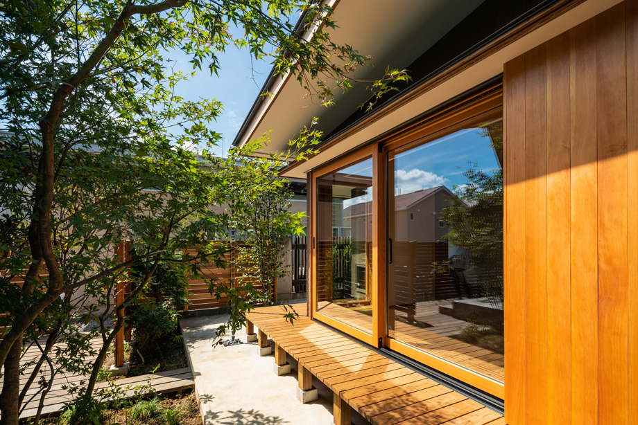 鎌ケ谷市「鎌ケ谷の家D」　木製全開サッシを閉じた状態の外観　庭の緑と縁側