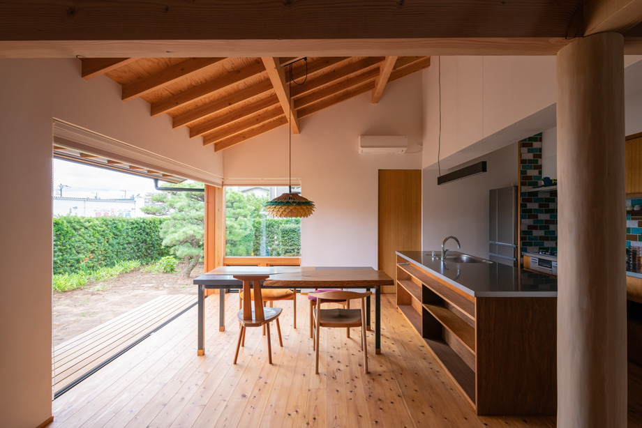 千葉県の平屋「ぼくらの家」木製全開サッシを全開した状態。 勾配天井と化粧垂木。 漆喰の空間